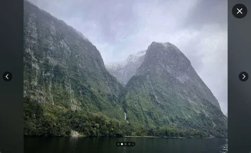 A Reddit gallery open full-screen on a photo of misty fjord peaks, with arrows to step to the next image